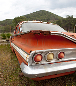 Photo of old rusty car in a field